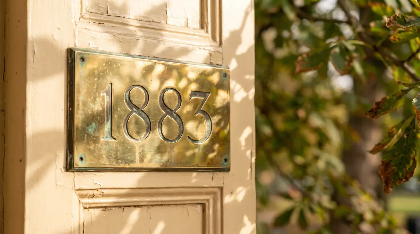 The brass 1883 number plate on the cream door frame at Studio Soothe, with Panhandle greenery behind