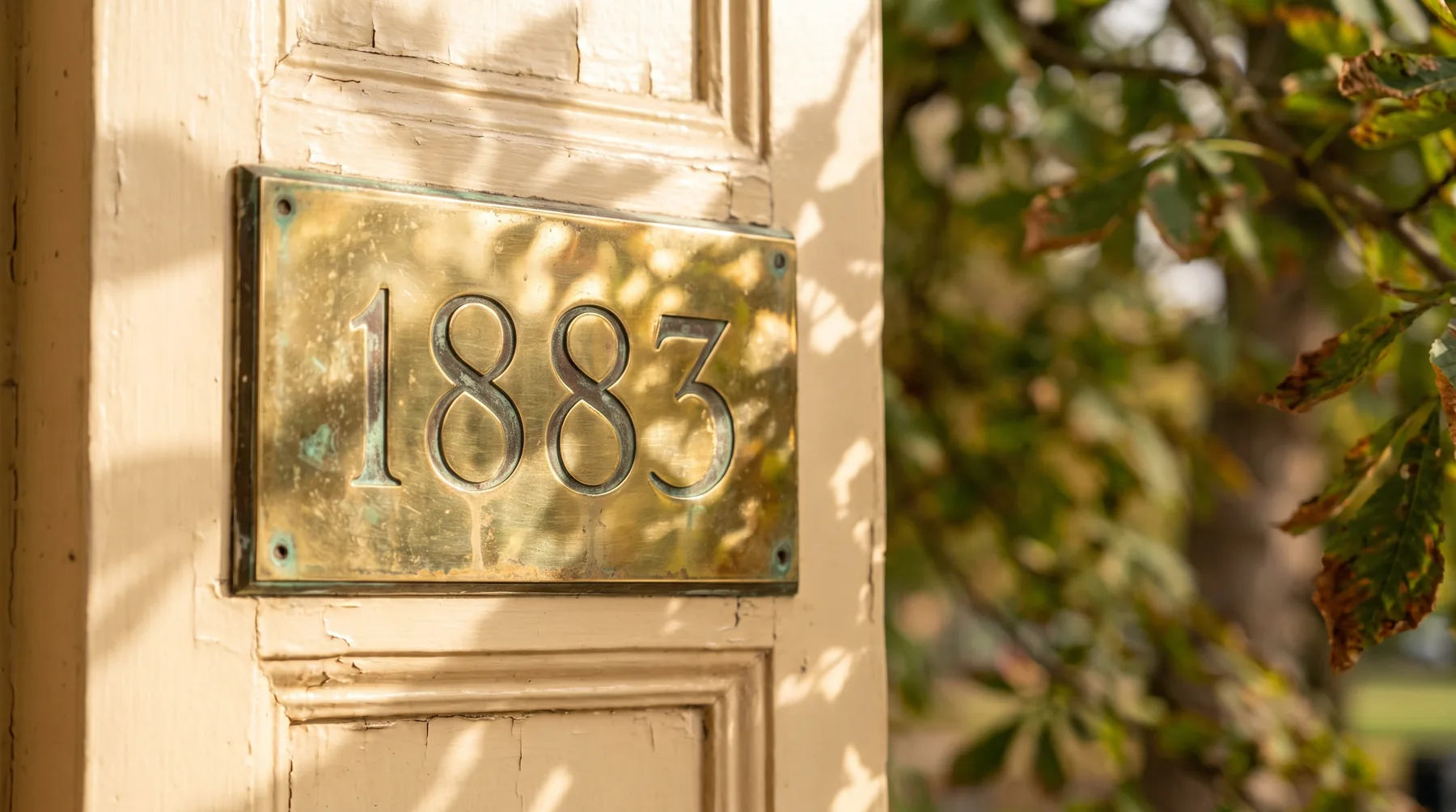 The brass 1883 number plate on the cream door frame at Studio Soothe, with Panhandle greenery behind